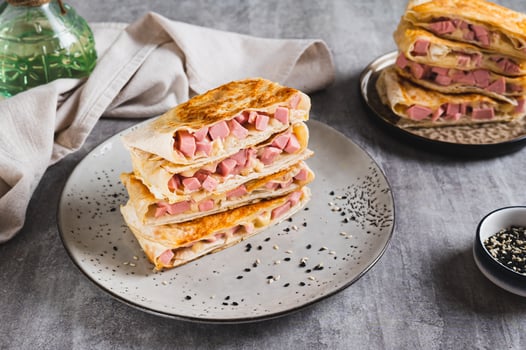 Crispy envelopes with sausage and cheese in flat bread on a plate on the table photo