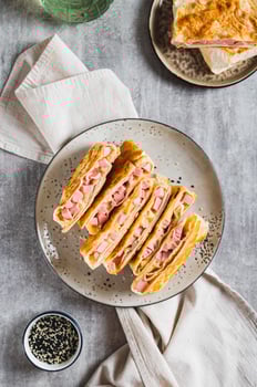 Crispy envelopes with sausage and cheese in flat bread on a plate top and vertical view photo