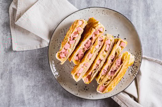 Close up of grilled sandwiches in pita bread with sausage and cheese on a plate top view photo