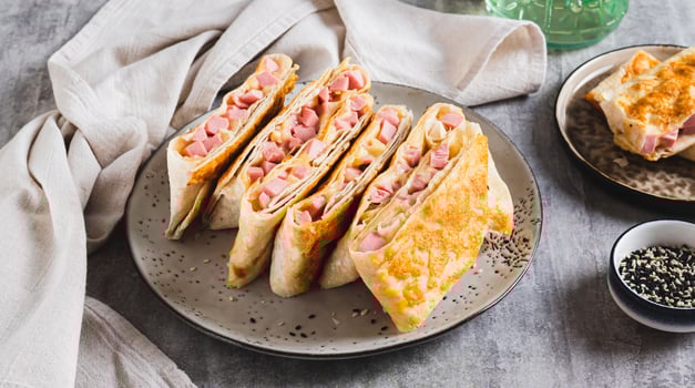 Grilled sandwiches in pita bread with sausage and cheese on a plate web banner photo