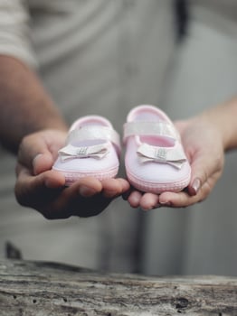 Couple holding baby's shoe photo