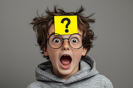 Surprised child wearing glasses with question mark on forehead photo