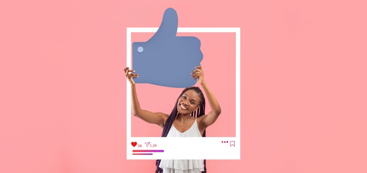 A young woman with long braids joyfully displays a large thumbs-up symbol in front of a pink backdrop. She exudes enthusiasm for her online content and social media presence. photo