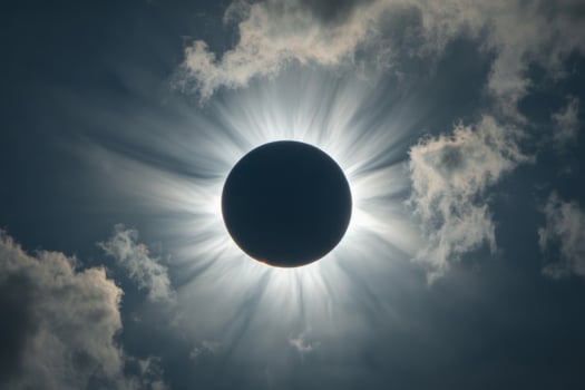 A breathtaking solar eclipse creates a dramatic halo effect over clouds during a celestial event photo