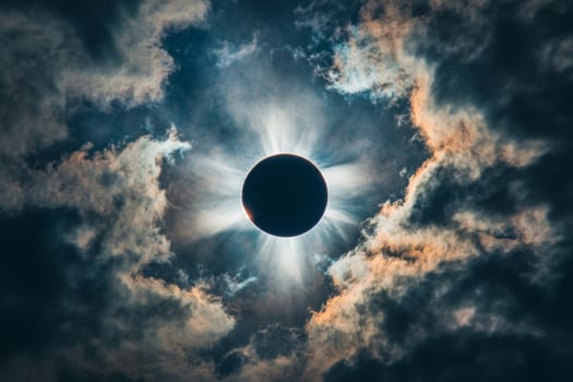 A stunning solar eclipse creates a dramatic halo effect over clouds during a celestial event in the afternoon sky photo
