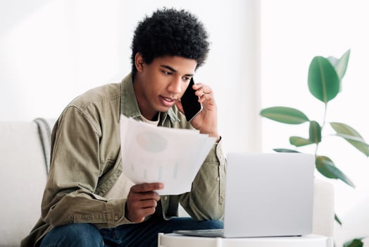 Serious black teen guy studying online from home, talking to his tutor about coursework paper on smartphone. African American college student discussing his educational project with teacher photo