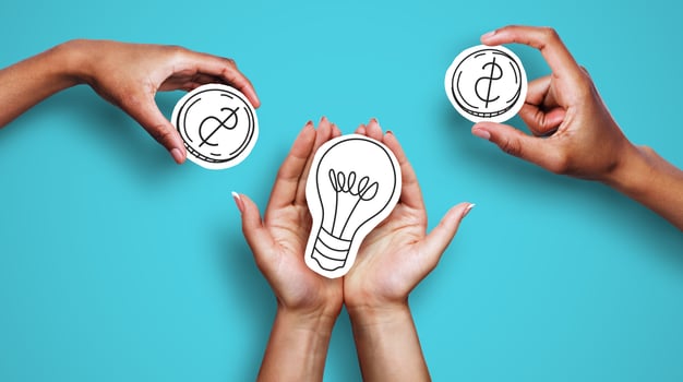 Money for startup, startup financing. Hands with dollar sign coins and light bulb over blue background, creator asking investors for money photo