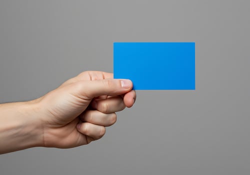 A hand holding a blue card on a gray background photo