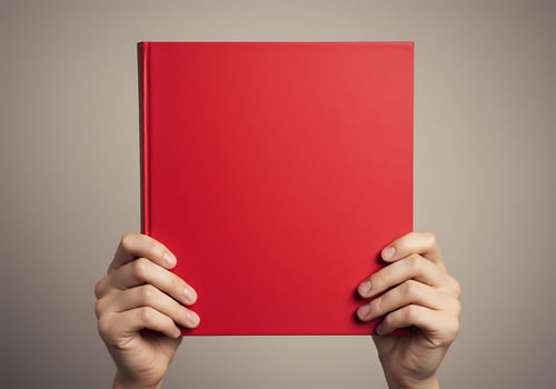 Hands holding a red book over a gray background photo