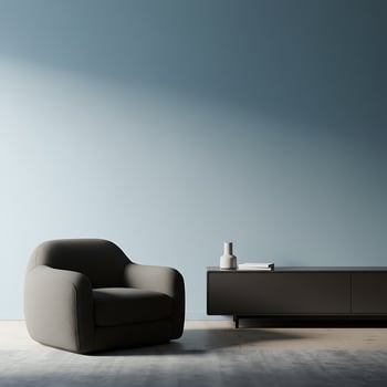 A grey chair and a tv stand in front of a blue wall photo