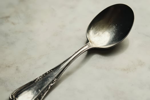 Beautiful silver spoon on a marble table surface photo