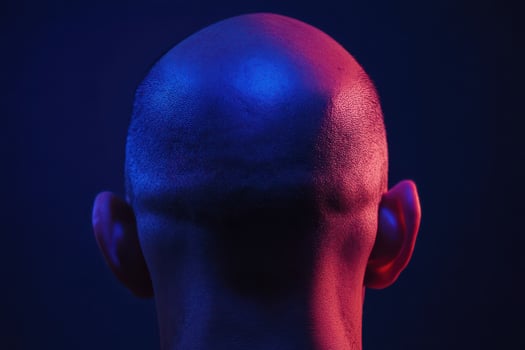 Bald head lit by colorful lights photo