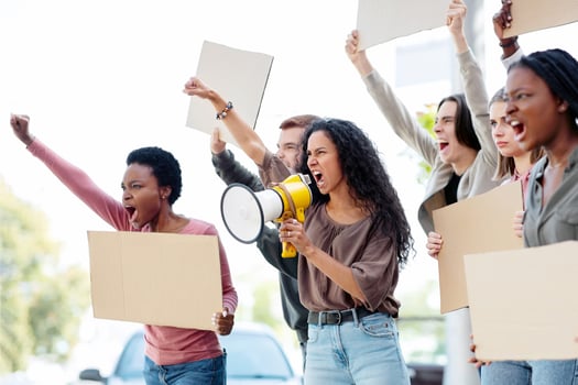 International group of people making strike on the street, using loudspeaker, holding blank placards, side view, copy space. Angree demonstrators fighting against war or animal abuse photo