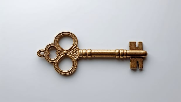 Vintage brass key resting on a clean surface showcasing its ornate design and historical significance photo