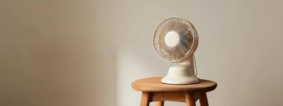 A fan sitting on top of a stool photo