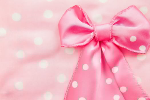 Bright pink bow with white polka dots on fabric photo