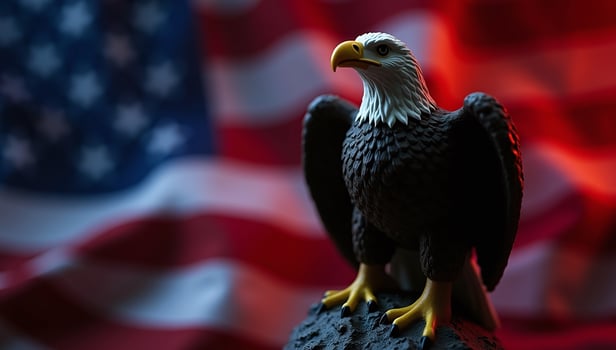 Bald Eagle Figurine Perched Against Abstract Patriotic Background photo