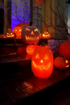Jack o' lanterns glowing on the steps of a porch photo