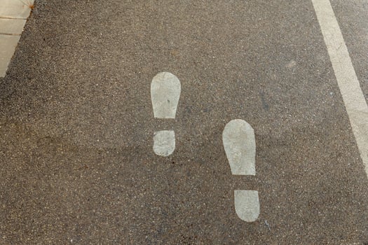 Footsteps guiding the way on a quiet urban pathway during a sunny afternoon stroll photo