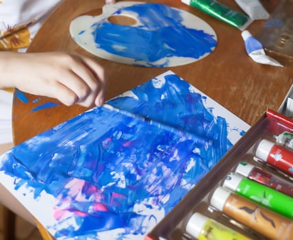 Close-up of a child hand smearing bright paints. Kids artistic creativity. photo
