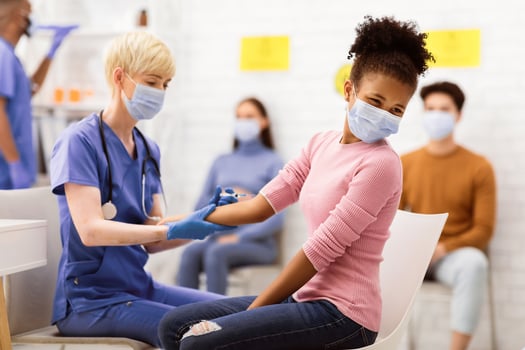 Covid-19 Vaccination. Doctor Vaccinating Black Teen Girl Against Coronavirus, Injecting Corona Virus Vaccine Injection In Arm Sitting In Hospital. Covid 19 Protection And Immunization photo