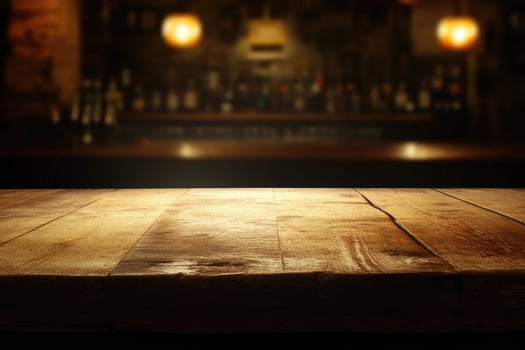 Empty wooden table in a dark room with blurred bar photo