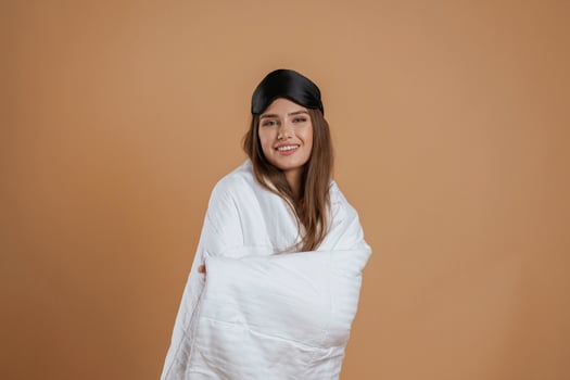 Wrapped in a blanket. Young ,,pretty woman is against background in the studio photo