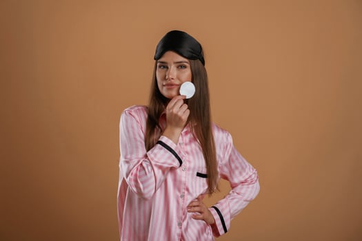 Skin care morning ,routine,, in pink pajama. Young pretty woman is against background in the studio photo
