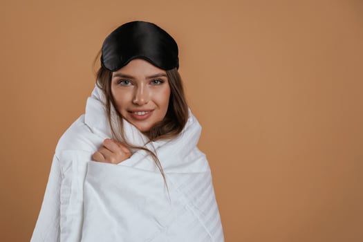 Wrapped in a blanket.., Young pretty woman is against background in the studio photo