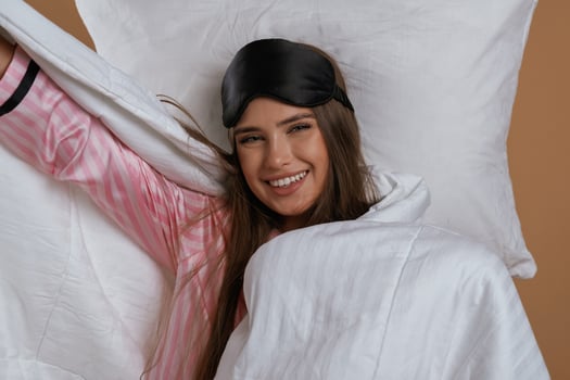 Just woke ,up,,, in pajama and on the pillow. Young pretty woman is against background in the studio photo