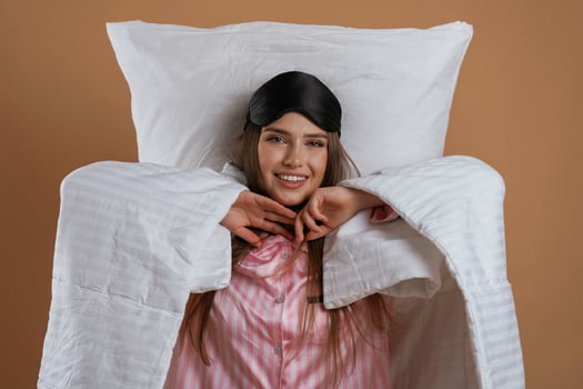 Just, woke,, up, in pajama and on the pillow. Young pretty woman is against background in the studio photo