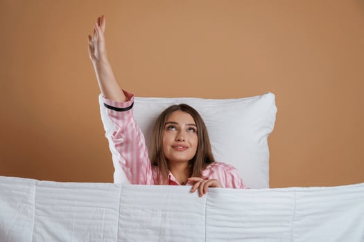 Lying ,,down on the pillow, in pajama. Young pretty woman is against background in the studio photo