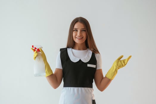 Chambermaid ,,is ,with ,cleaning product and tool. Young pretty woman is against background in the studio photo