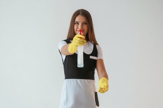 Chambermaid is, with,,, cleaning product and tool. Young pretty woman is against background in the studio photo