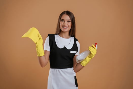 Young chambermaid is ready for cleaning... pretty woman is against background in the studio photo