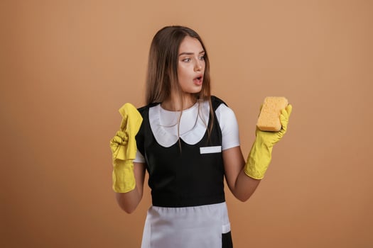 Unsatisfied chambermaid. Young pretty, woman is against background in the studio photo