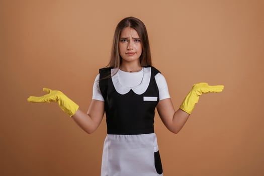 Unsatisfied chambermaid. Young pretty woman is against background in the studio photo