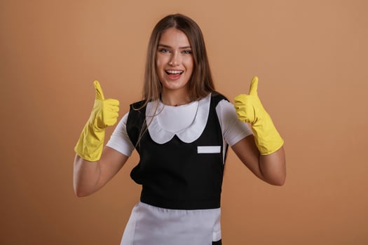 Brown backdrop,,, chambermaid is standing. Young pretty woman is against background in the studio photo