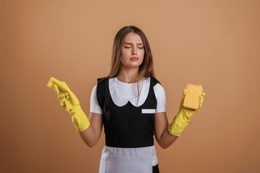 Unsatisfied chambermaid. ..Young pretty woman is against background in the studio photo