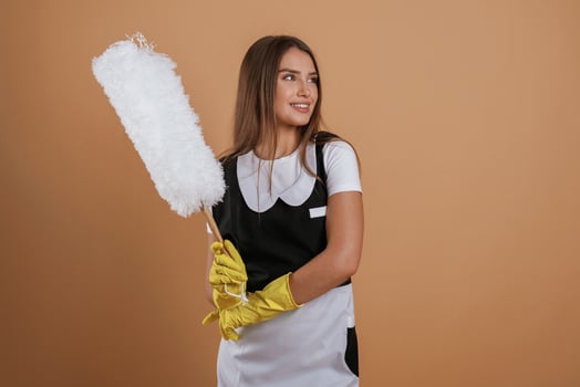 Big white cleaning thing in hand. .Young pretty woman is against background in the studio photo