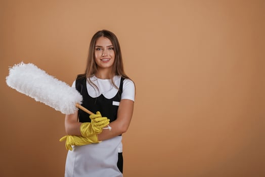Big white cleaning thing in ,hand. Young pretty woman is against background in the studio photo