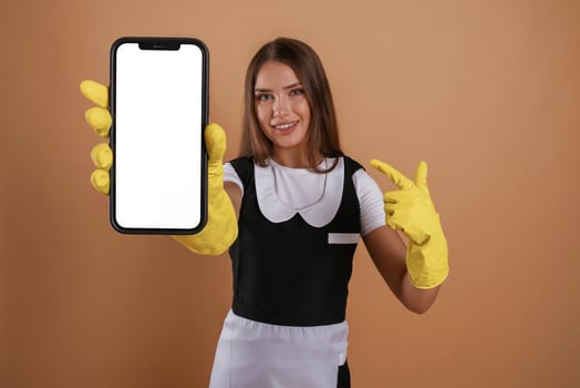Smartphone with copy, space, ,,chambermaid is standing. Young pretty woman is against background in the studio photo