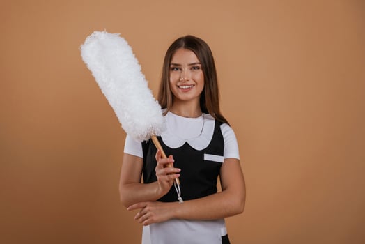 Big white cleaning ,thing in hand. Young pretty woman is against background in the studio photo