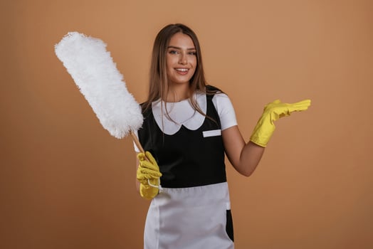 Big ,white ,cleaning thing in hand. Young pretty woman is against background in the studio photo