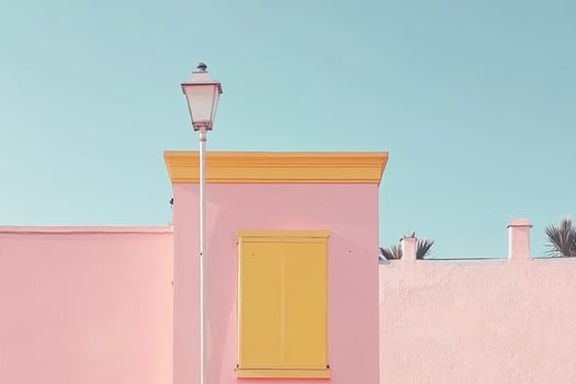A pink building with yellow shutters and a street lamp photo