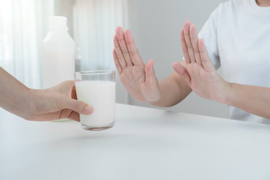 Milk allergens, woman confused milk, runny stuffy sore nose suffer from intolerance allergy trigger symptoms. abdominal pain, allergens, nut protein, rash, death, food allergy photo