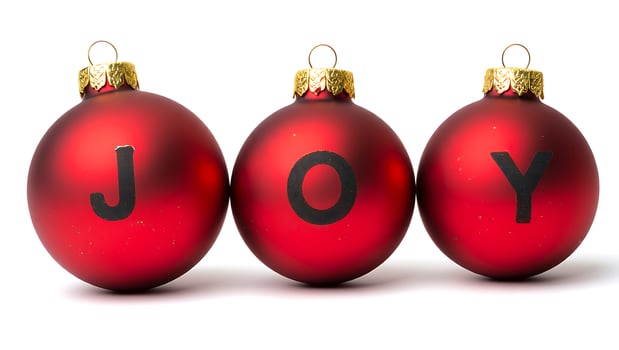 Festive christmas baubles arranged to spell joy against a clean white background symbolizing holiday cheer and celebration photo