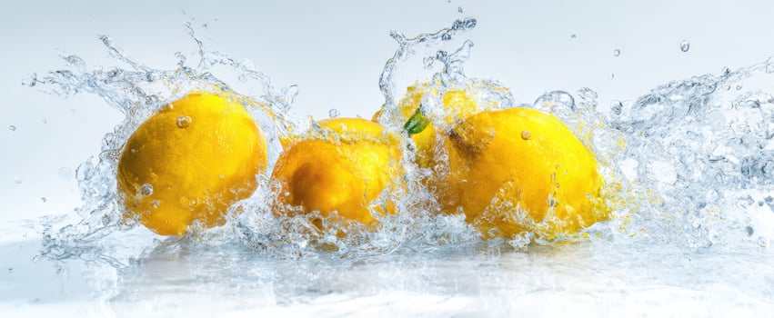 The vibrant lemons splashing in crystal-clear water create a refreshing scene. photo
