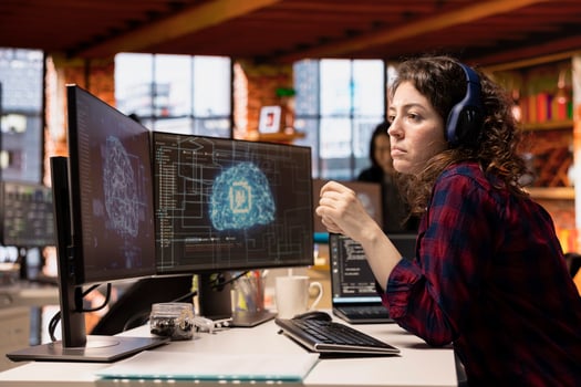 AI industry startup technician coding and listening podcasts in office to make time pass faster. Silicon Valley company worker wearing audio headset leveraging machine learning technology in workspace photo