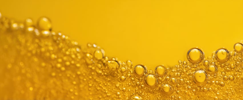 The vibrant bubbles rising in a refreshing yellow beverage under bright lighting. photo
